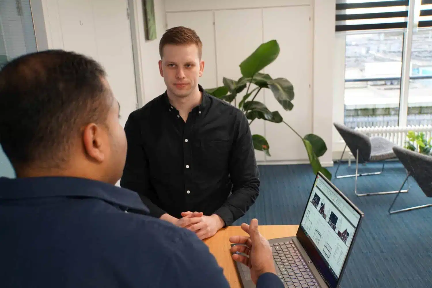 Klant bespreekt bouwkundig plan met constructeur in kantooromgeving